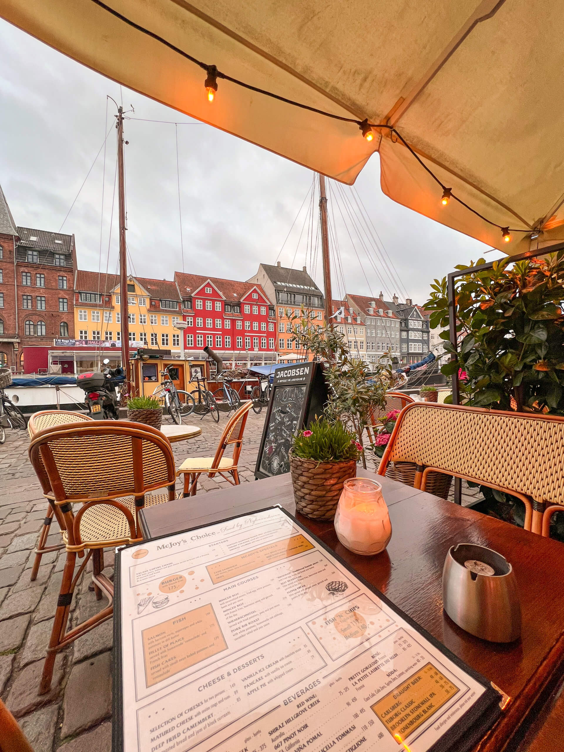 A view out from a restaurant table in Nyhavn, across to the red and yellow buildings opposite. One of my top 10 places to visit in Copenhagen.