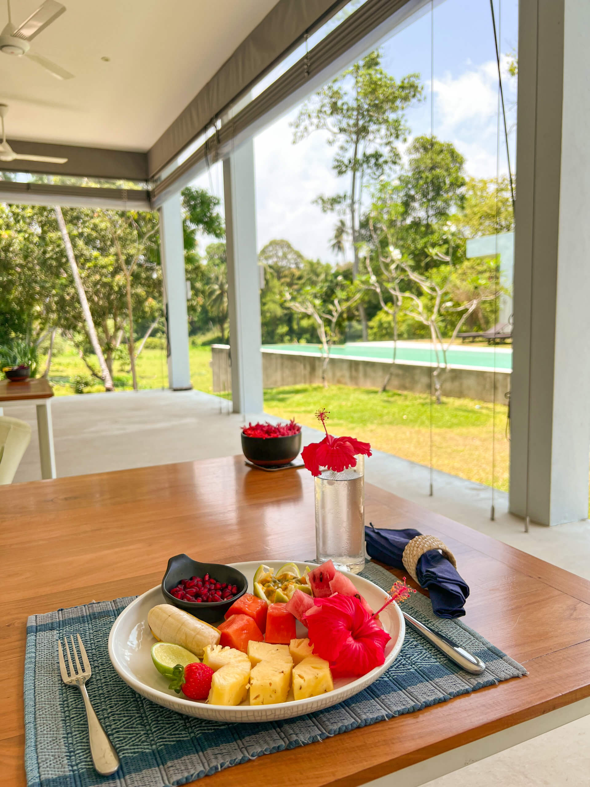 Beautiful fruit platter looking out onto the pool and jungle at Uyana Resort, one of the best introvert friendly places to stay in Sri Lanka.