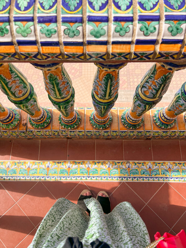 View down at my feet with decorative green, blue and yellow tiles - 10 things to do in Seville.