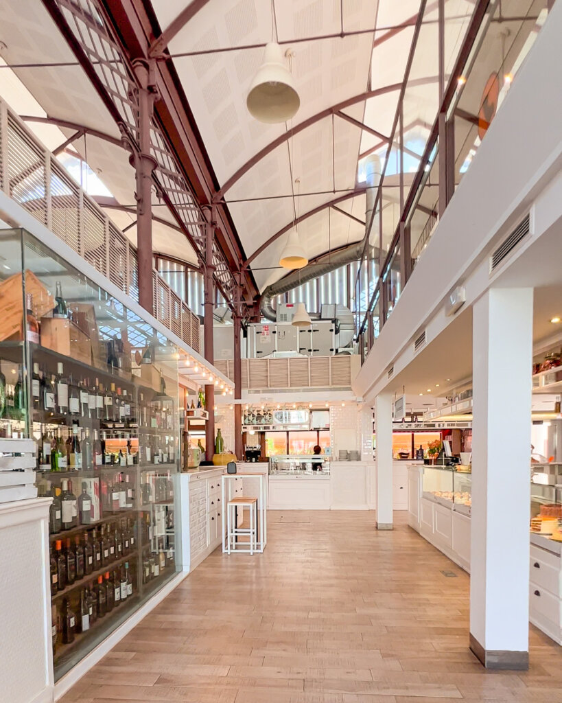 View of the Mercado Lonja del Barranco with wine bottles on the left and a deli counter on the right - 10 things to do in Seville